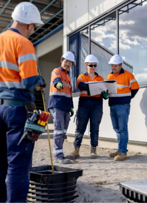 Electricians in high-visibility gear working with underground electrical power cables (2)